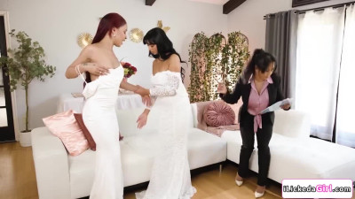 Lesbian couple scissoring in front of their wedding planner